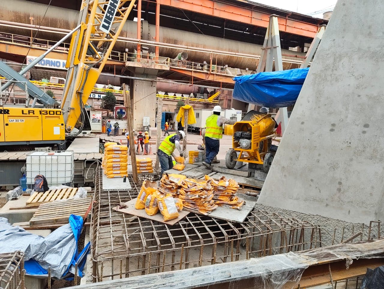 Frente de obra con grúa, jumbo y equipo de protección